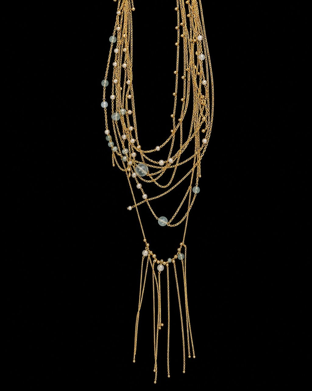 Gold Multistrand Aqua Tassel Necklace on a black background