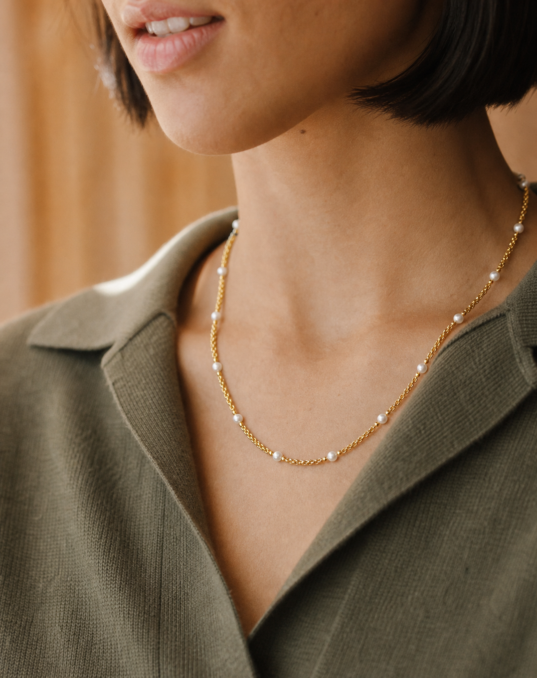 Fine necklace layers worn close to the collarbone